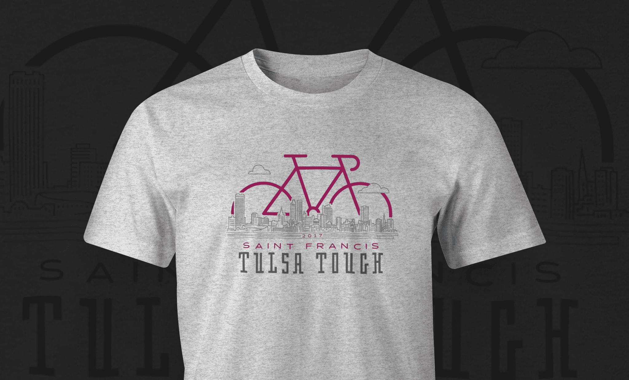 A light gray heathered shirt with a bicycle design combined with an illustration of the Tulsa skyline on the chest