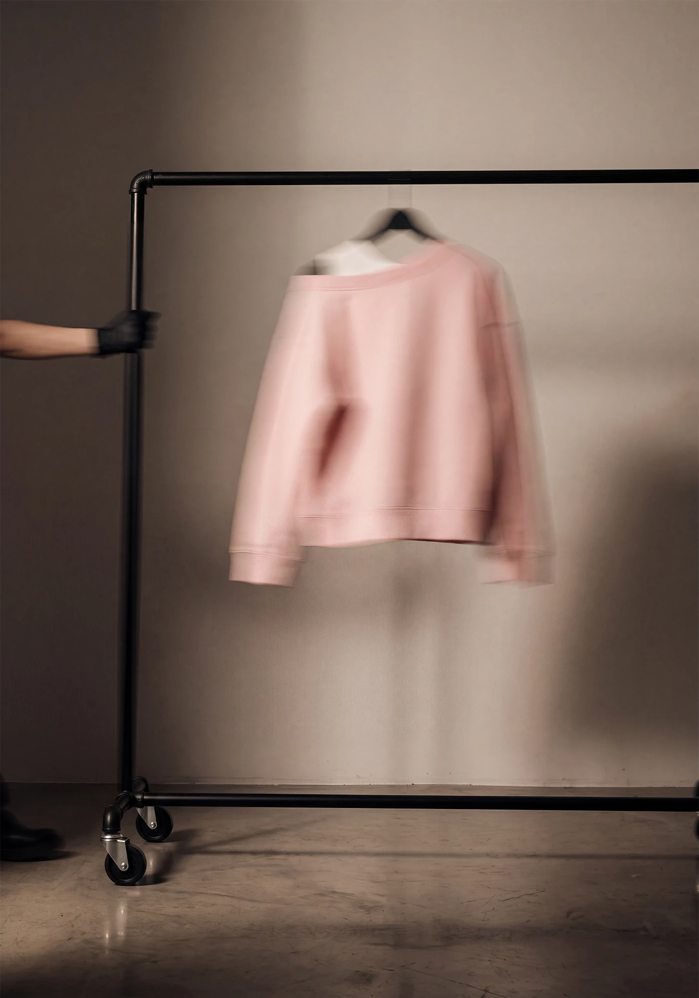 AI-assisted art direction study: pink garment suspended on a studio rail