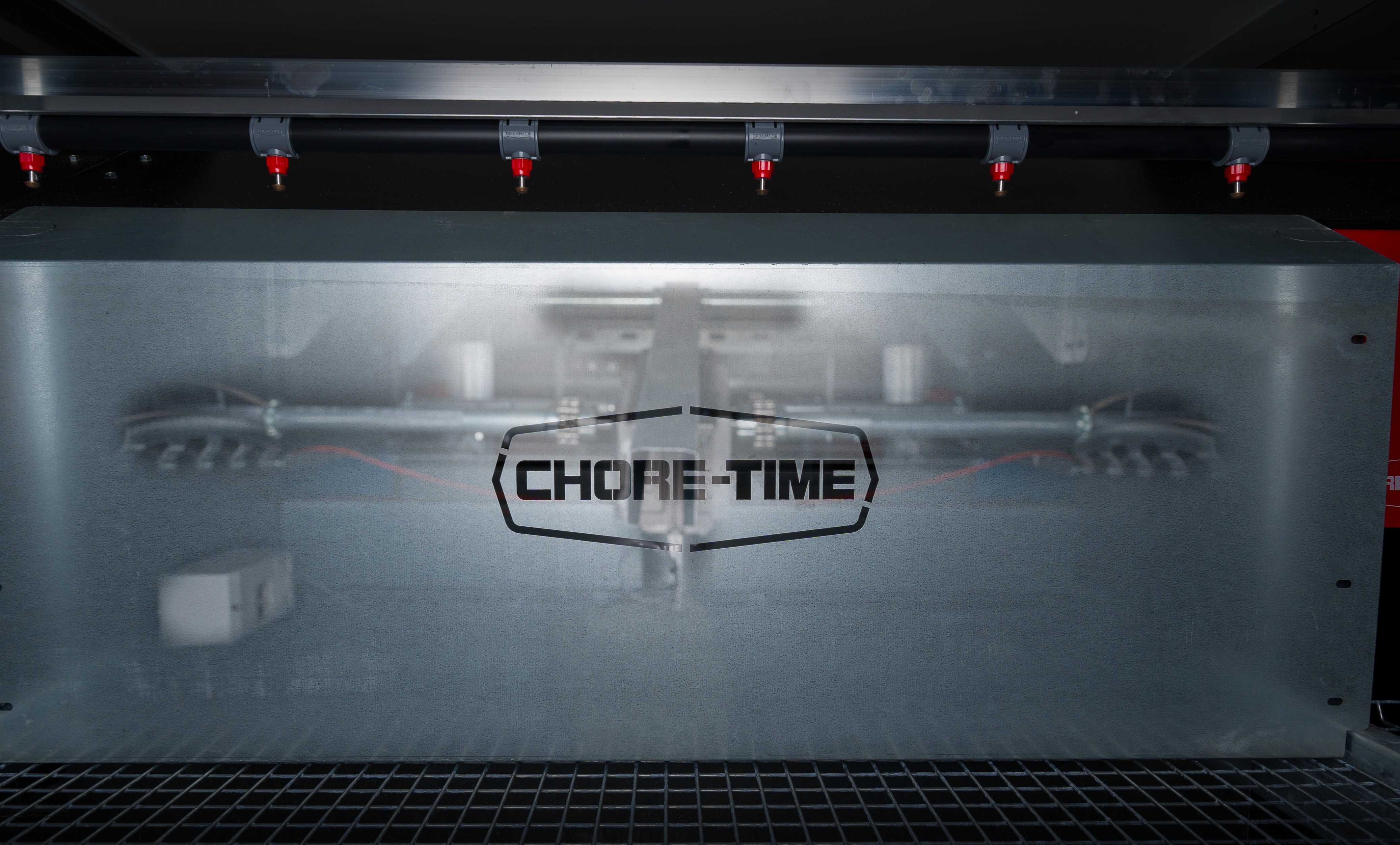 Gegalvaniseerde bak met het Chore-Time-logo onder een rij rode drinknippels