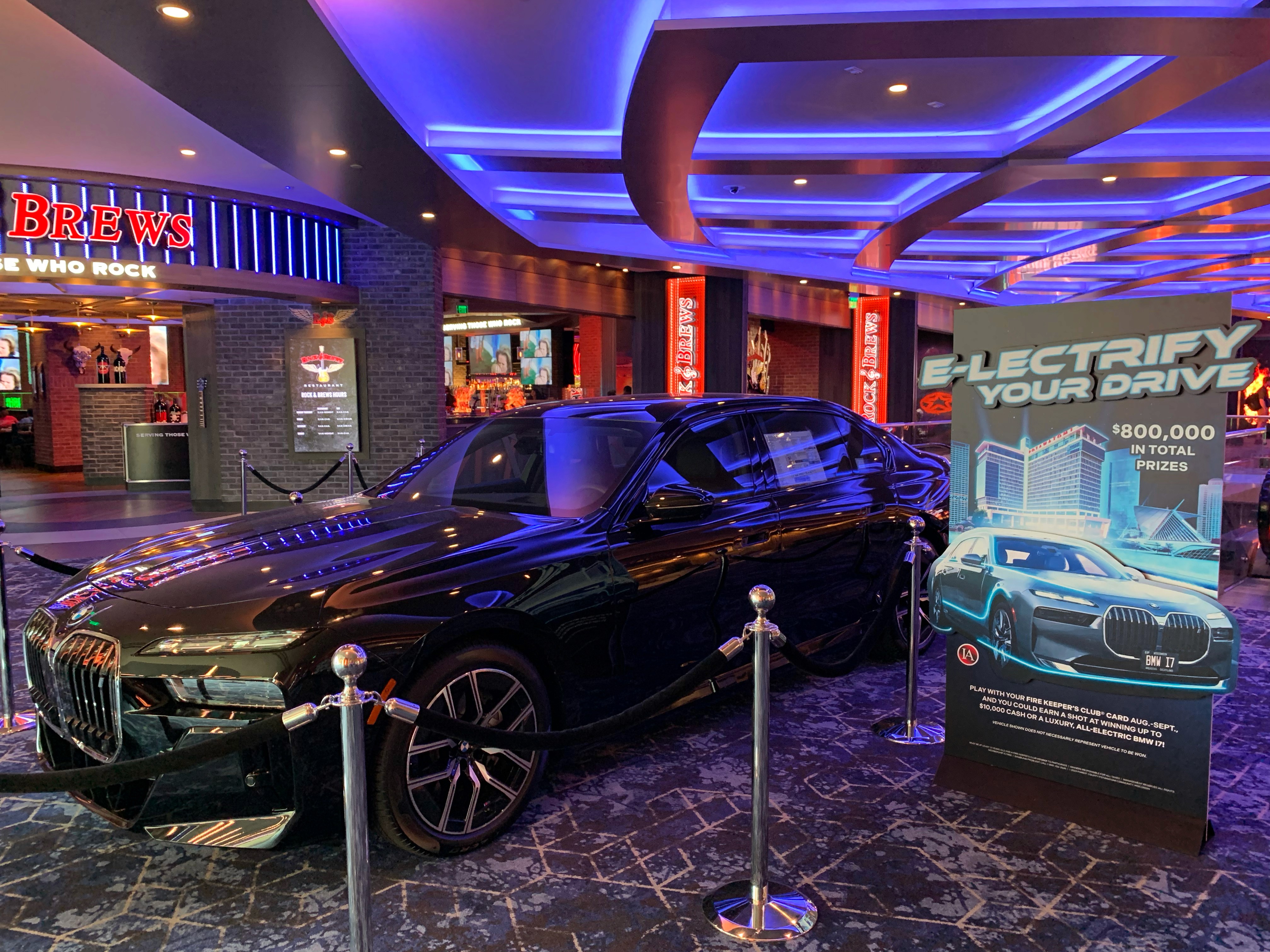 BMW i7 with standee next to it reading "E-lectrify Your Drive"