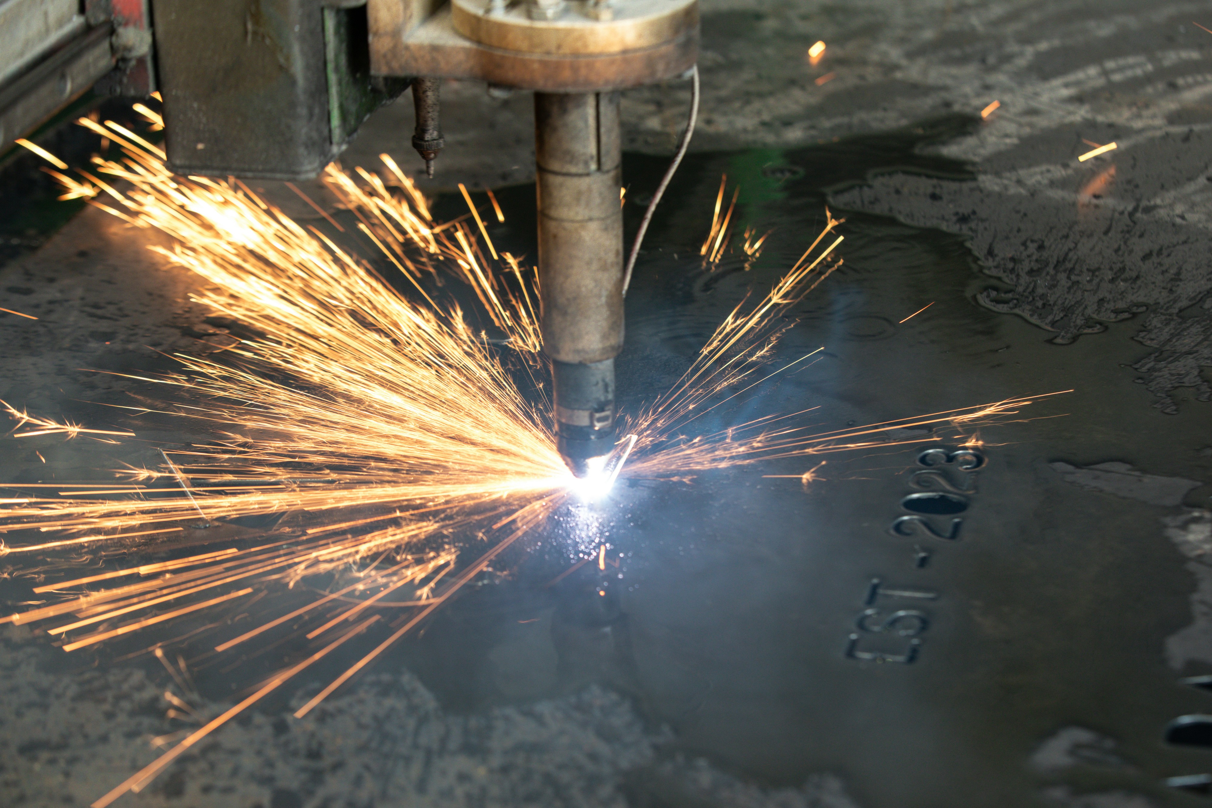 a welder cutting a piece of metal with sparks