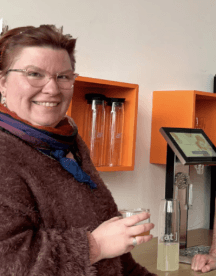 Office manager Dawina smiling with a fresh drink in her hand