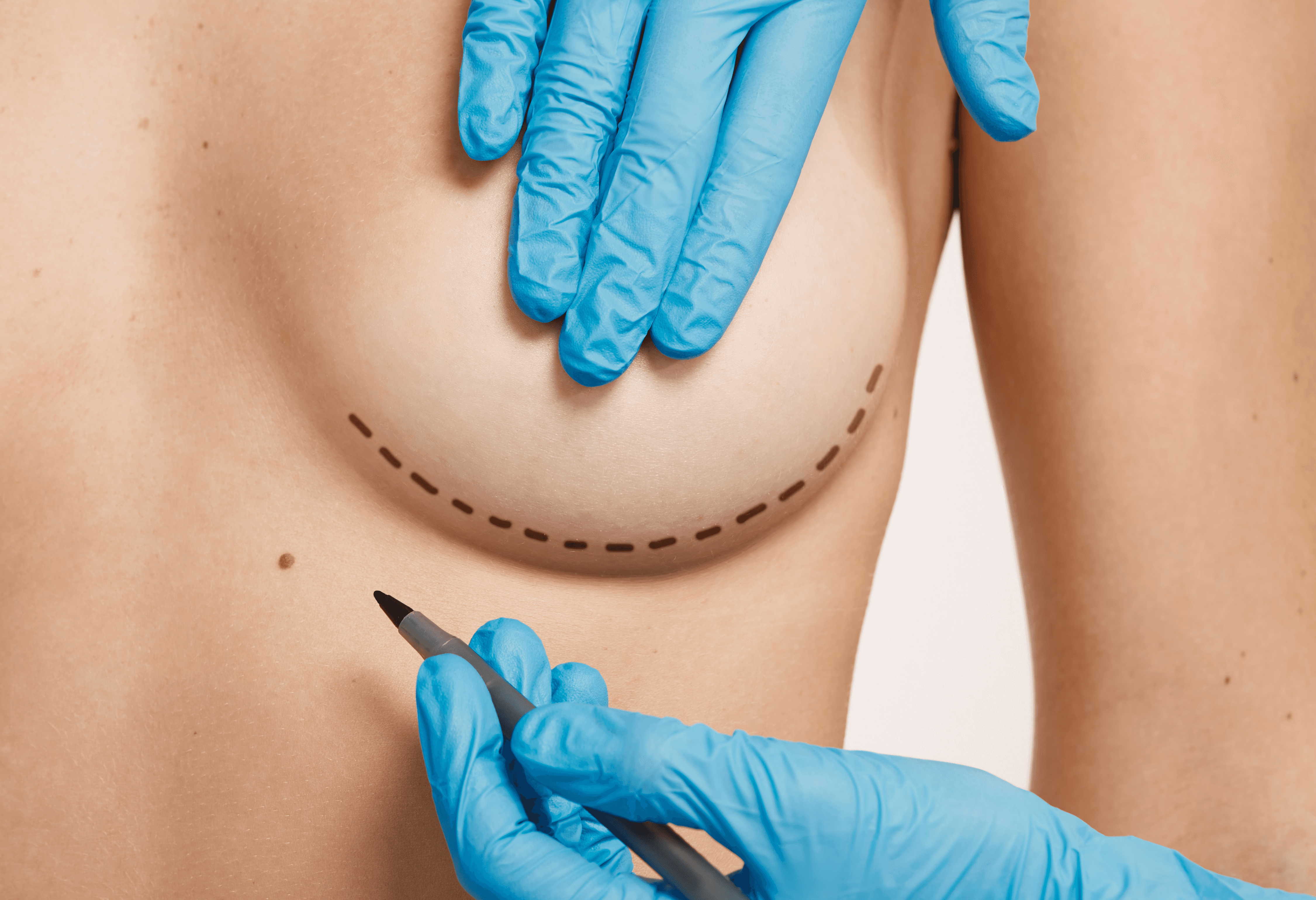 Woman in orange shirt looking up at blue sky