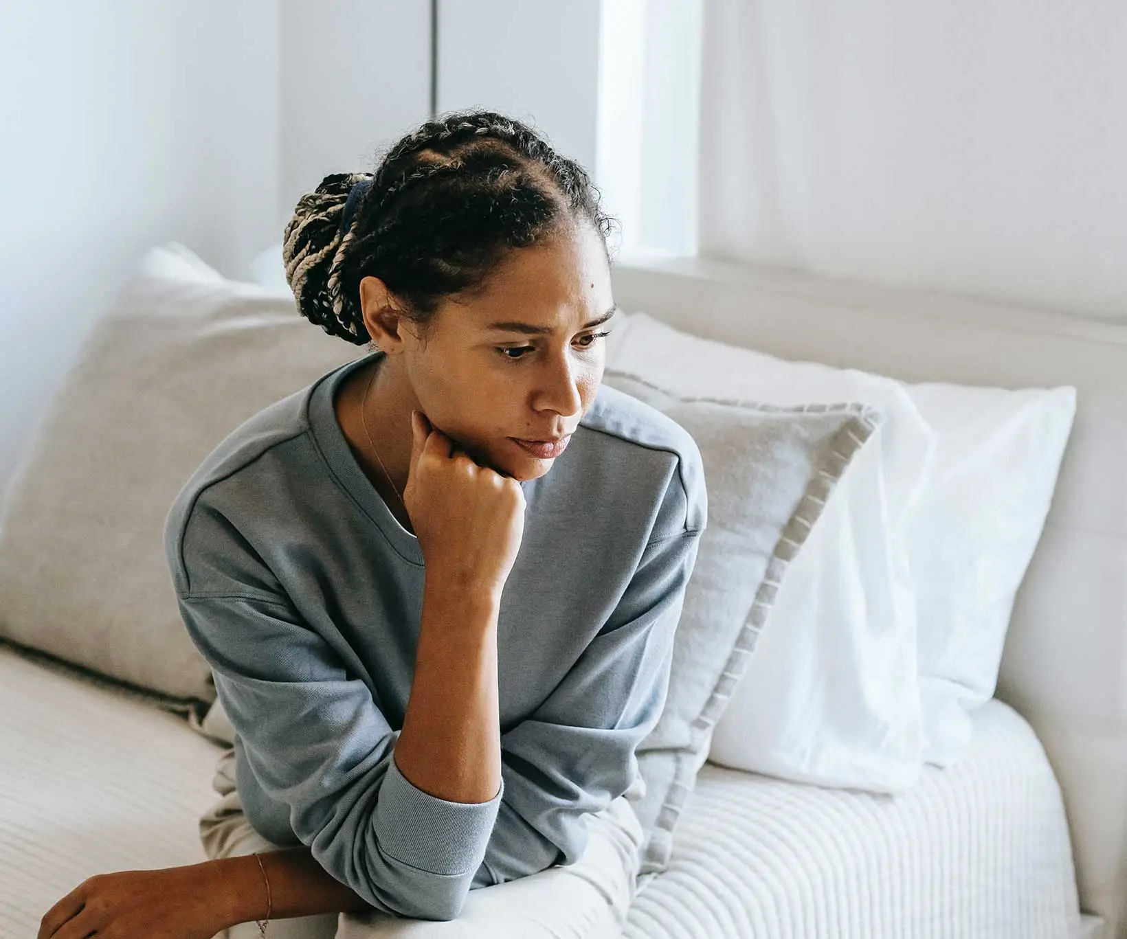 Une femme se questionannt sur son lit de la présence de punaises de lit