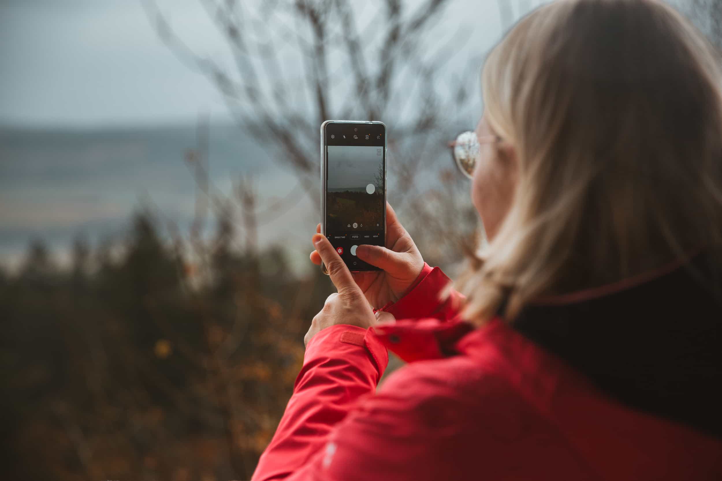 Woman with a red jacket and a phone in her hand