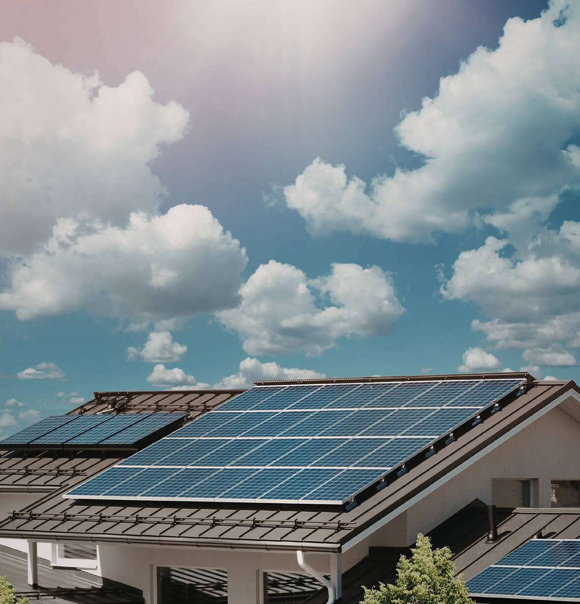 Solar panels fitted across a modern residential rooftop under a clear blue sky