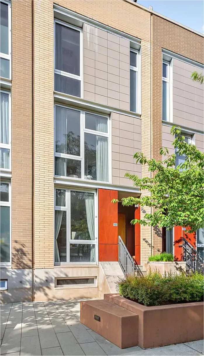 A tall building with numerous windows stands prominently along the street, showcasing modern architecture.