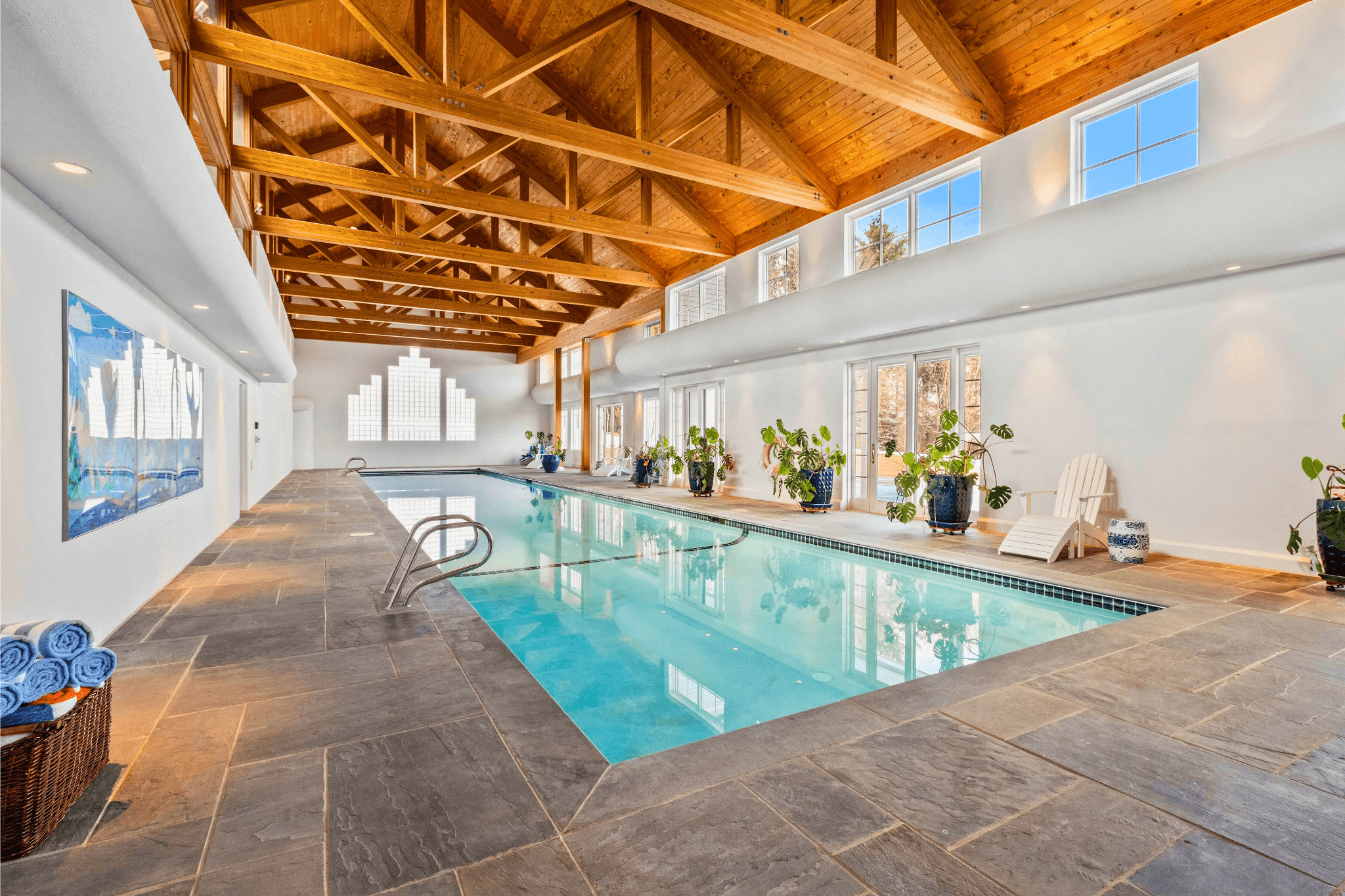 Heated Olympic-size indoor pool with vaulted wood-beam ceilings and skylights, a standout amenity in this top-tier New Hampshire vacation rental.