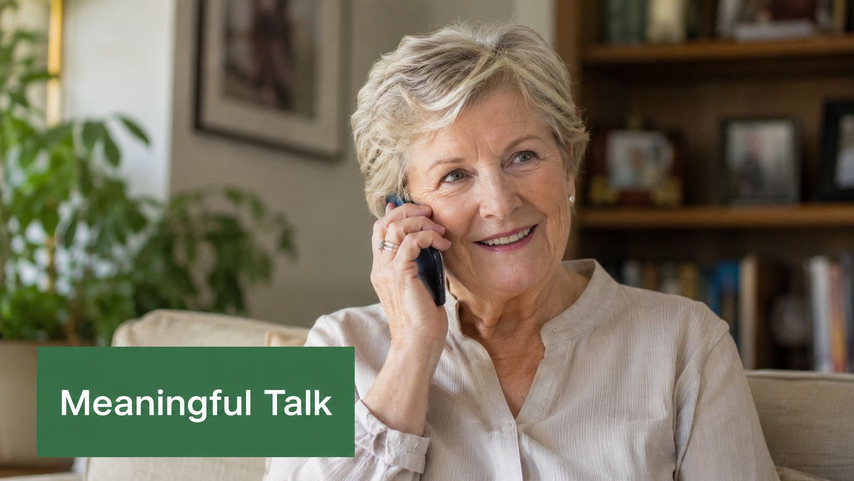 An elderly woman smiling warmly while having a meaningful phone conversation in her cozy home.
