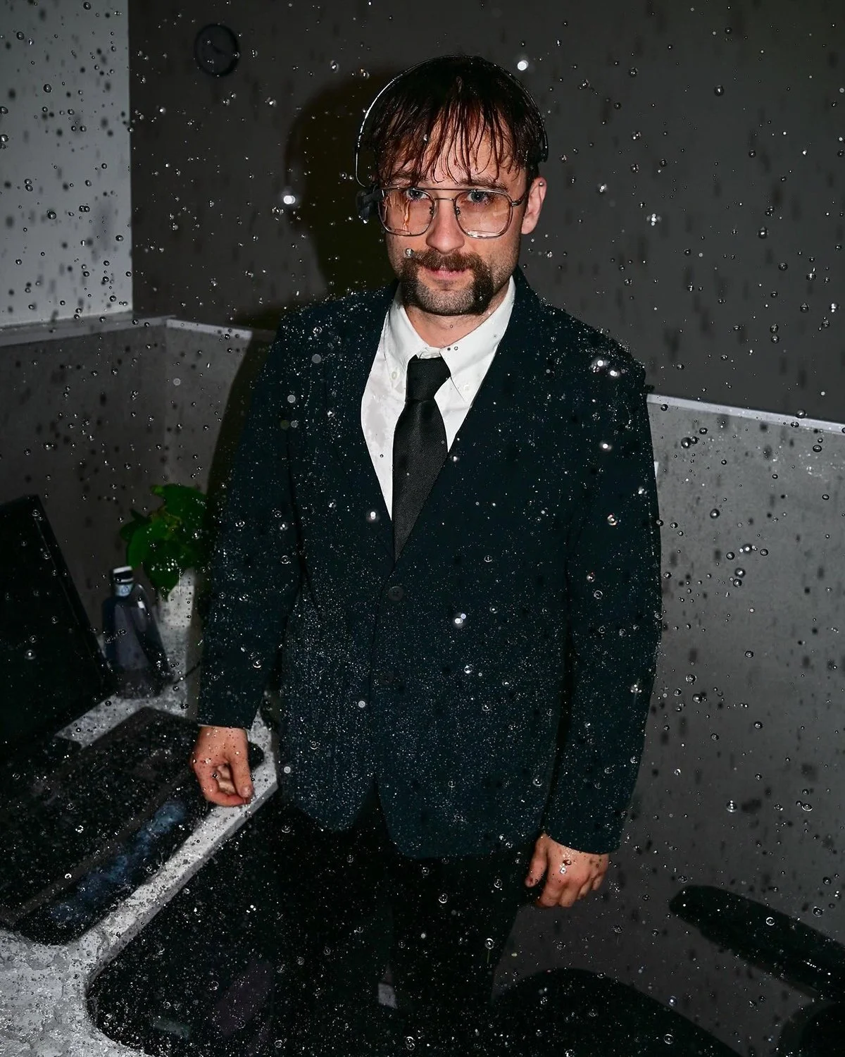 A fluffy gray rabbit rests on a floral chair.