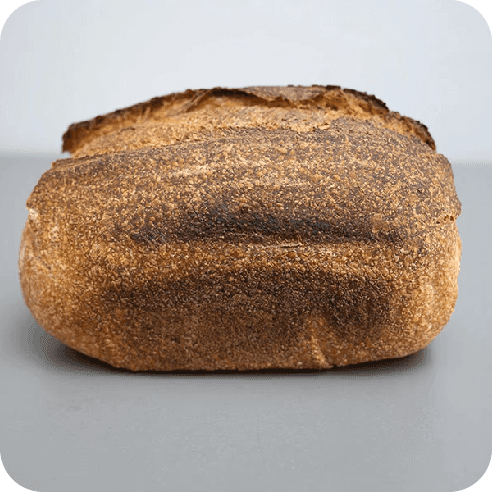 Pan semi integral de masa madre visto de lado, con corteza crocante y fermentación lenta.