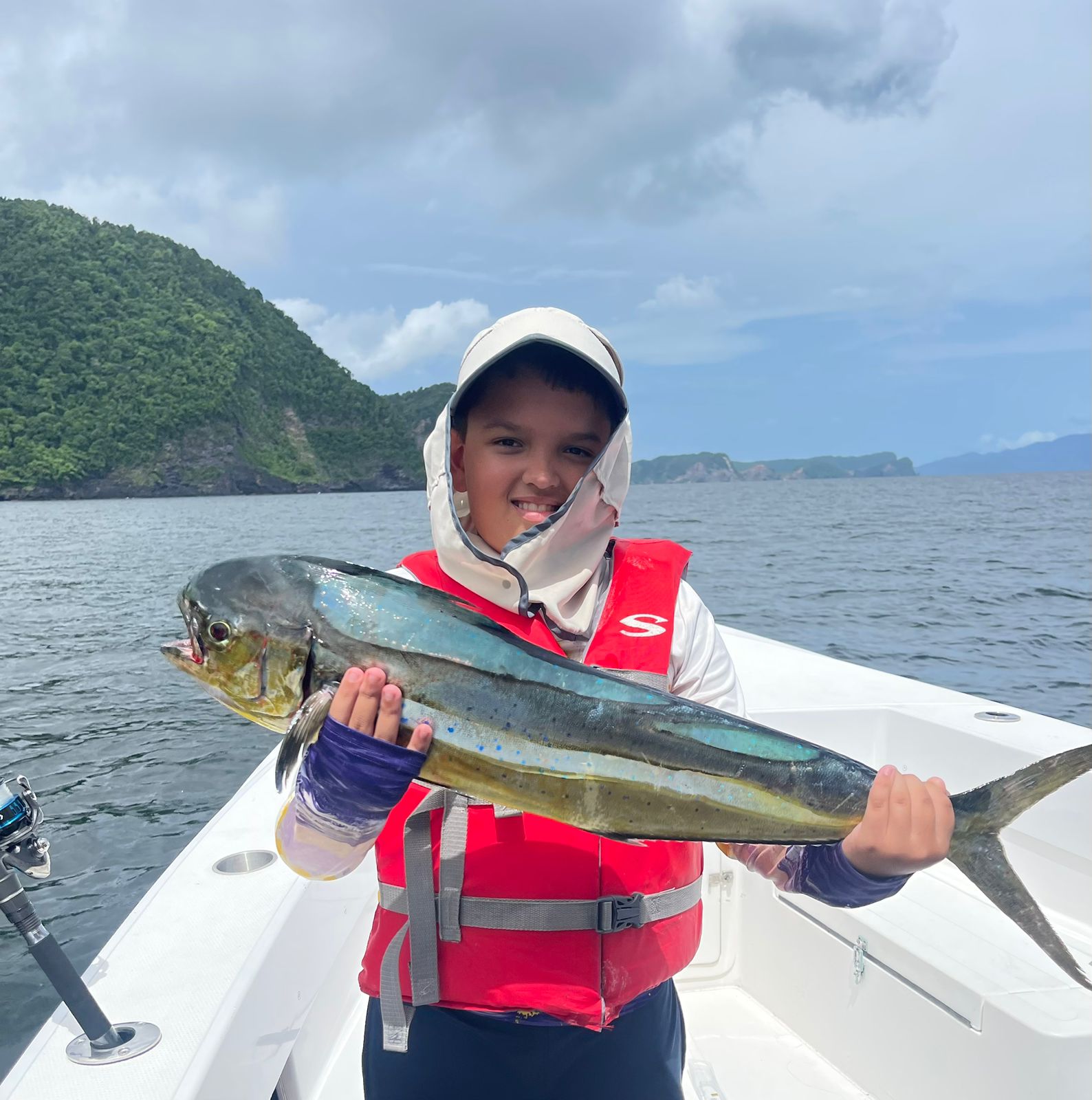 A young boy holding a Mahi Mahi