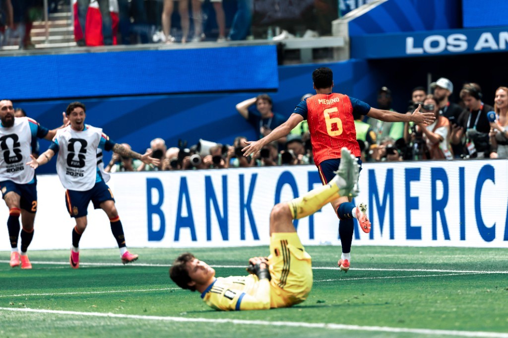 Spain's Mikel Merino celebrates a goal while the Belgian goalkeeper lies on the pitch during the 2026 World Cup quarterfinal in Los Angeles