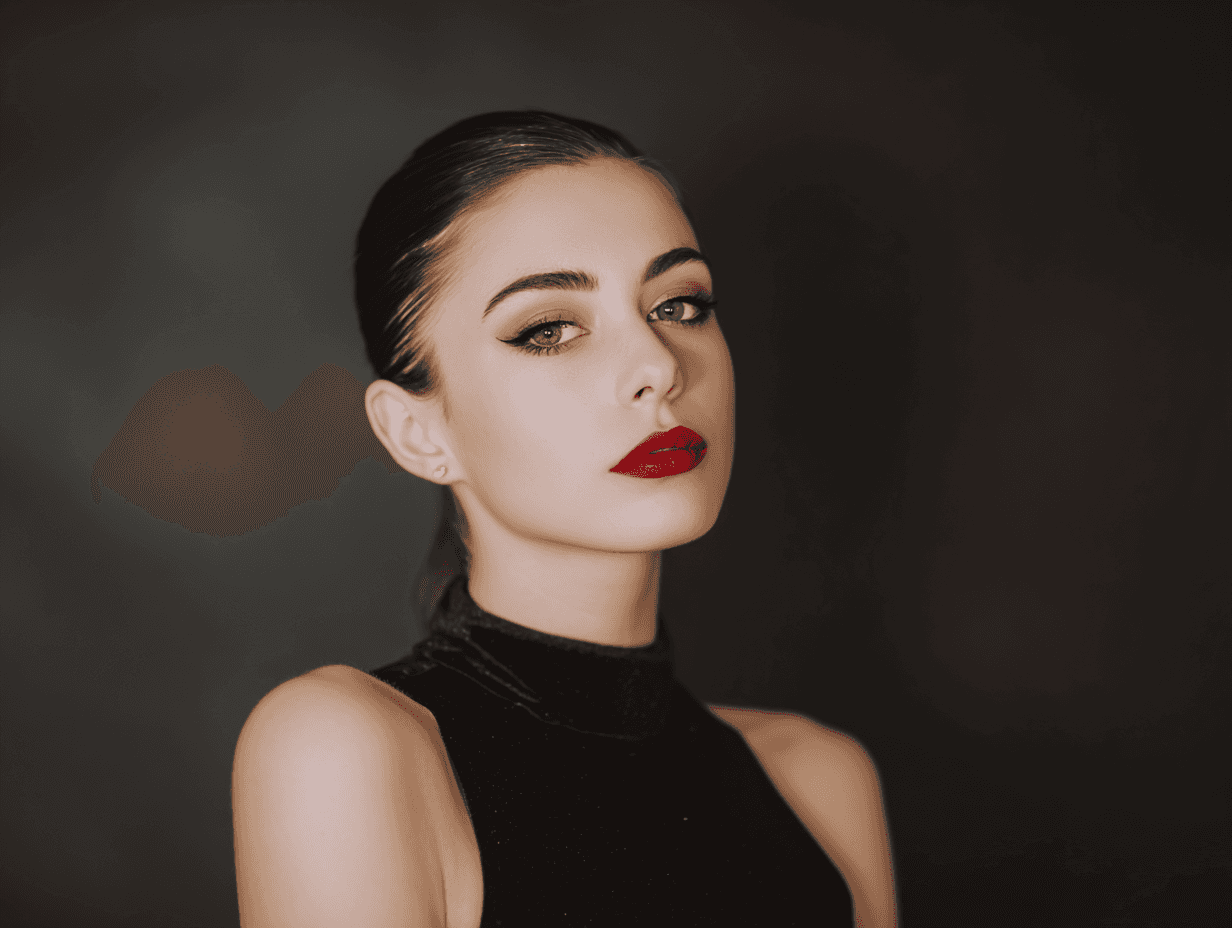 A woman with dark hair and red lips poses confidently against a dark background, wearing a black outfit.
