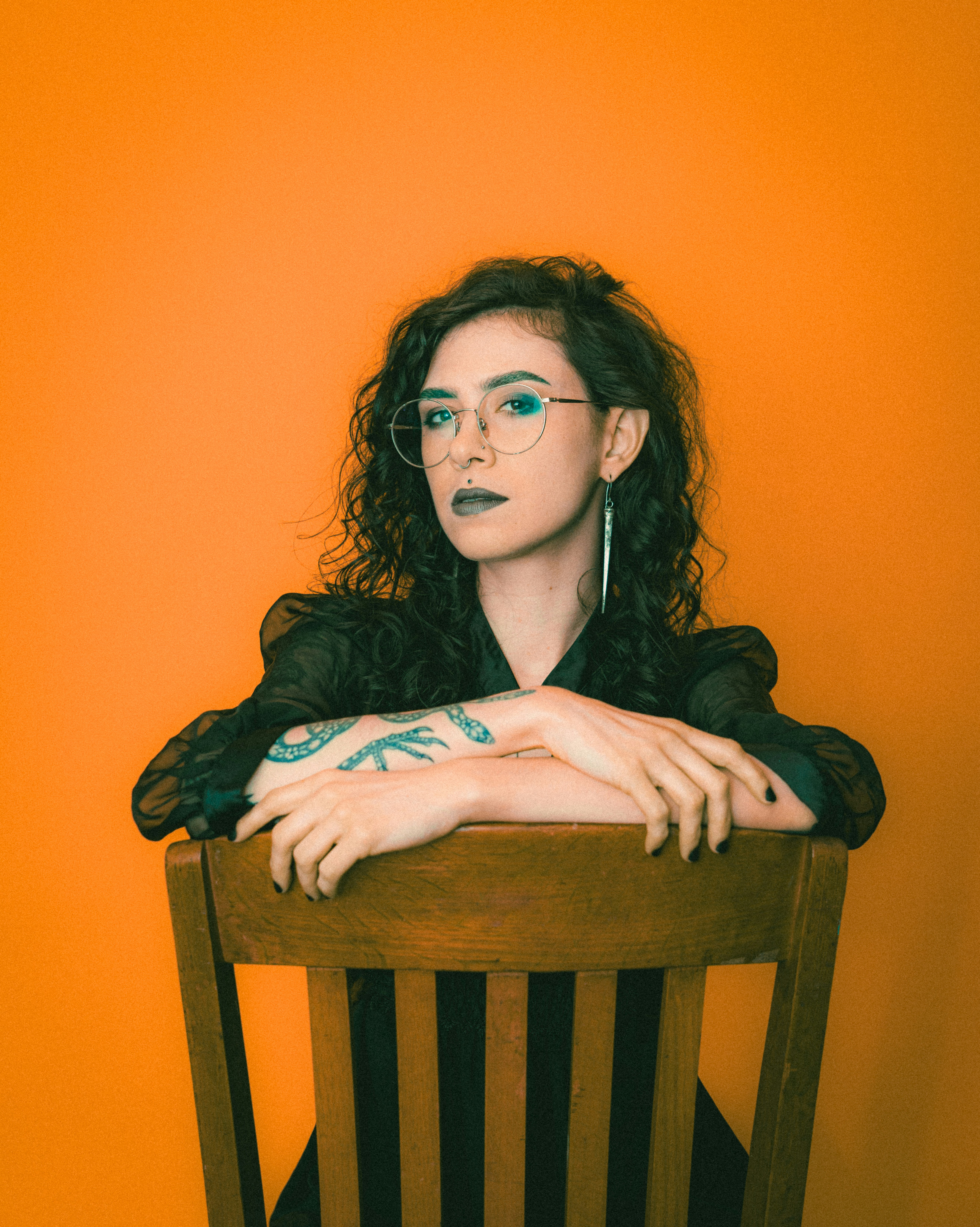 retro photo of a tattooed woman sitting on a chair