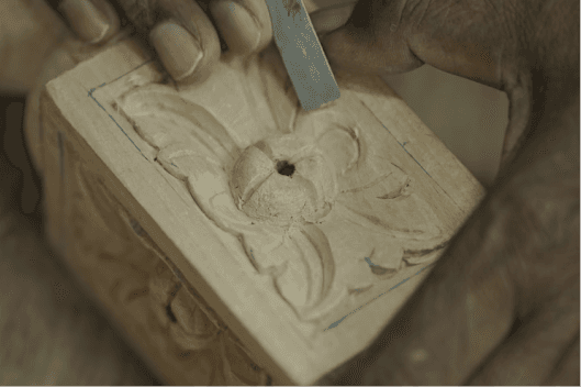 A craftsperson shaping timber by hand
