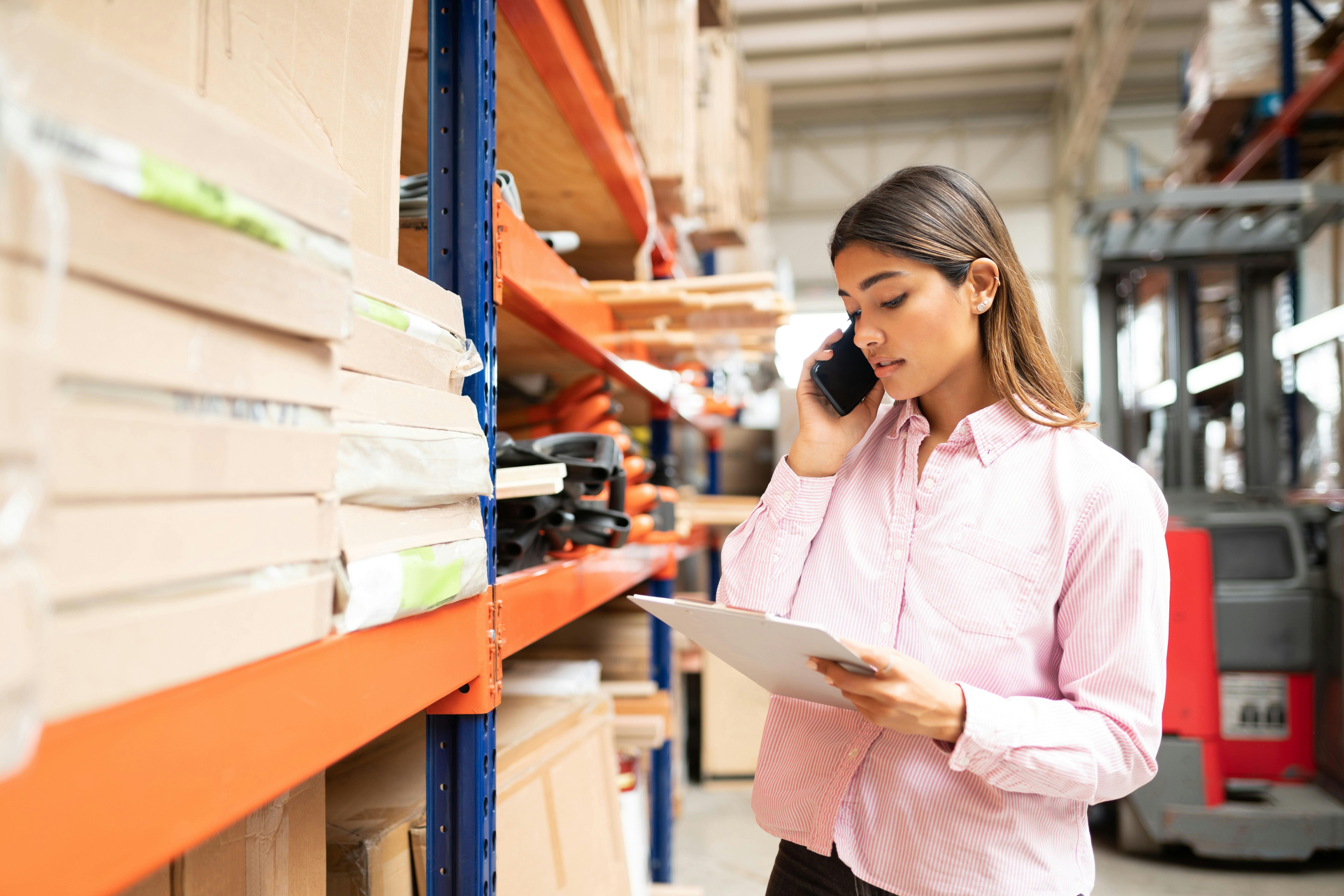 female business owner on the phone in a warehouse
