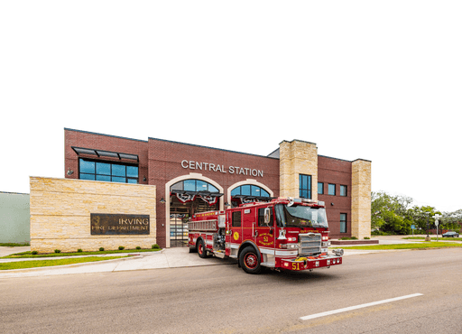 Irving Central Fire Station with fire engine 51 in front, brick and stone façade and arched bay