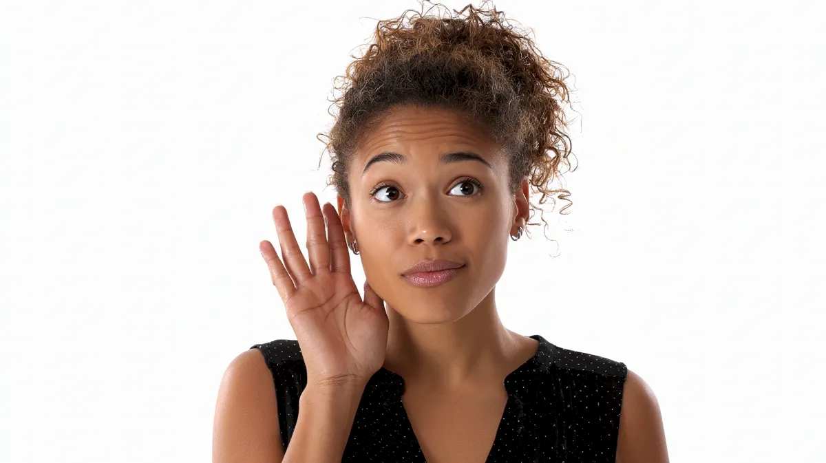 a woman is putting a pair of earplugs on her ear