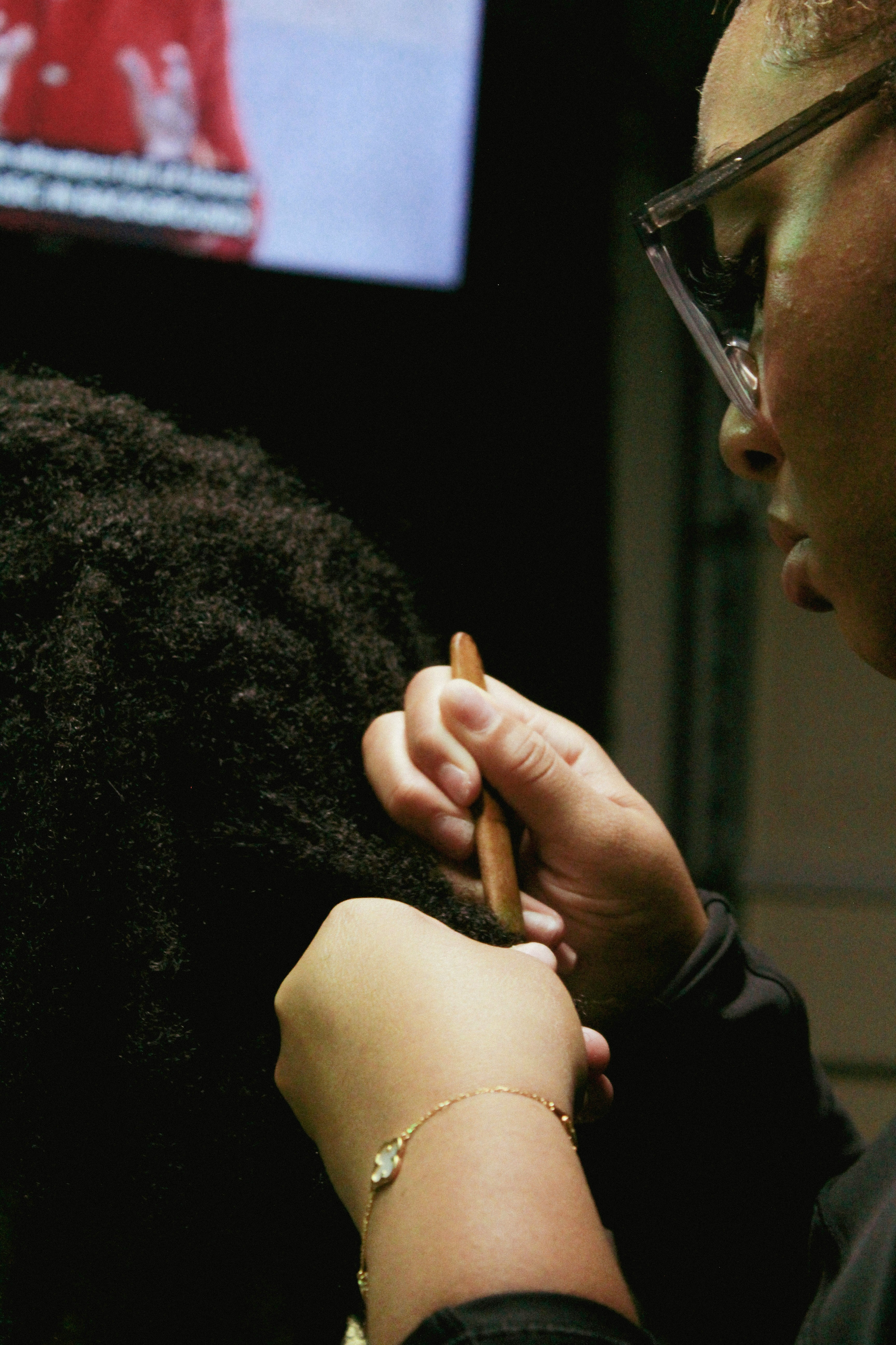 a woman getting her hair done by a man