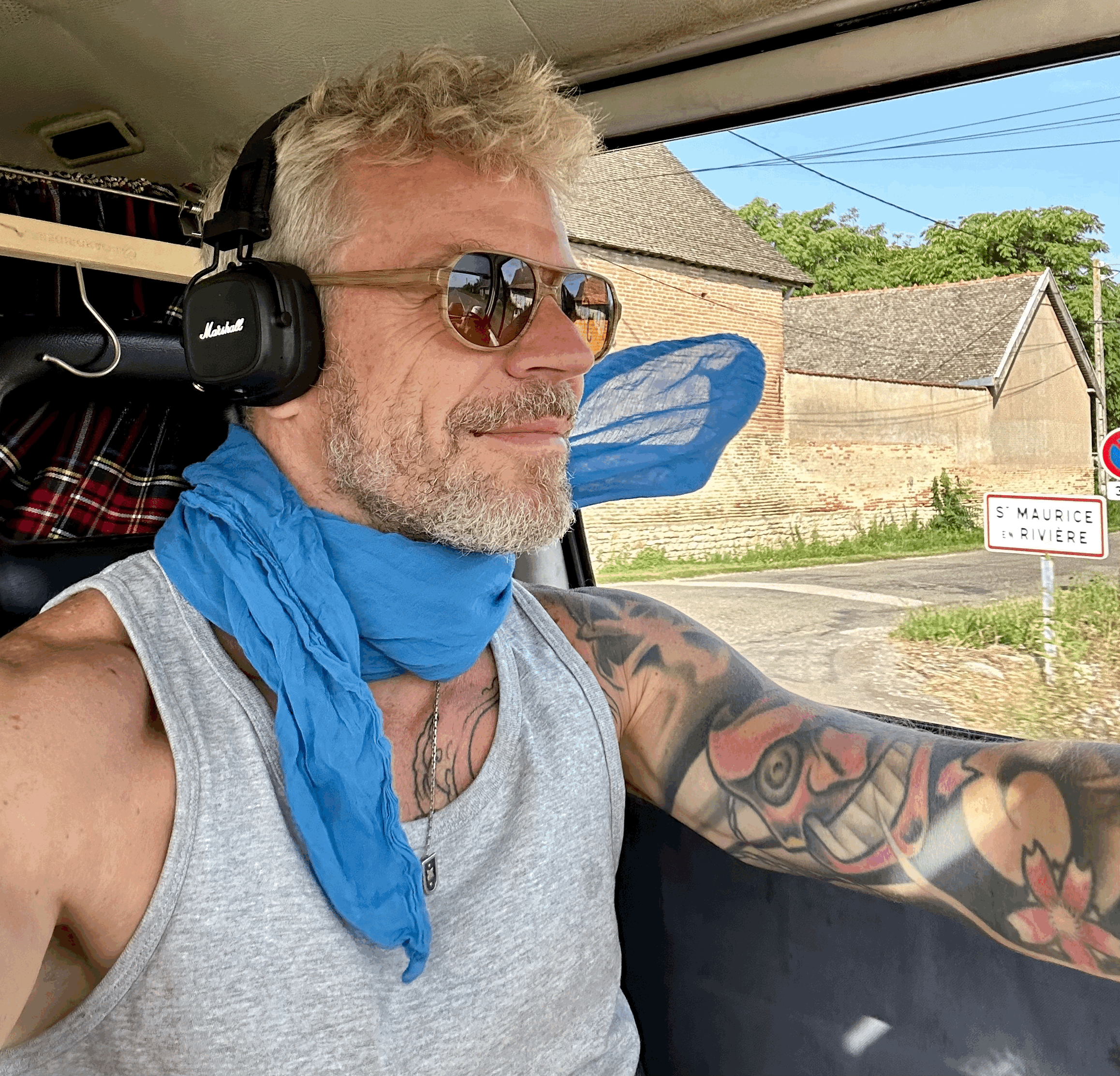 lifestyle szne im VW Bulli Best Ager Mann sitzt am Lenkrad und hört Musik