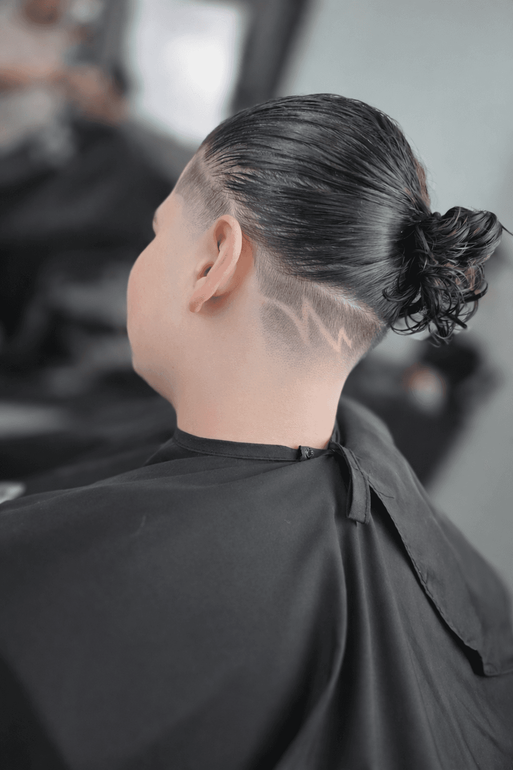 a man cutting another mans hair with a pair of scissors