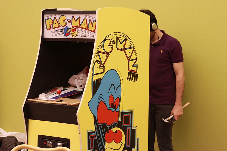 a man with a hammer behind a game machine