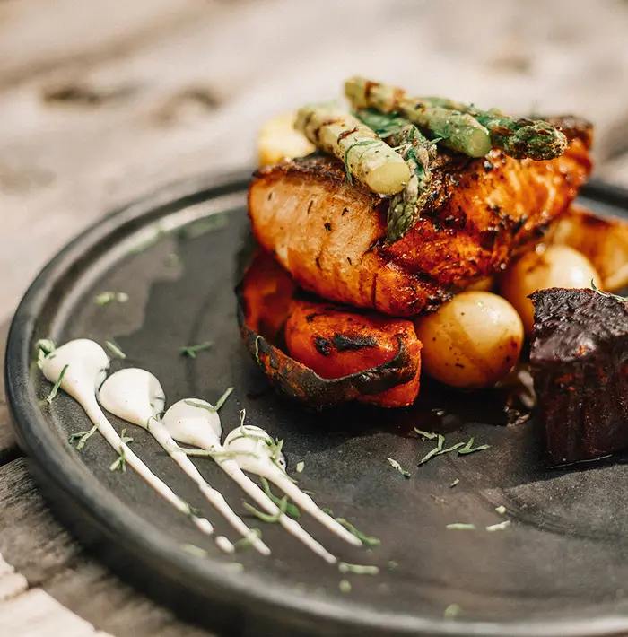 Juicy and exquisite grilled fish served with vegetables at La Popular restaurant in Nômade Tulum, Mexico.