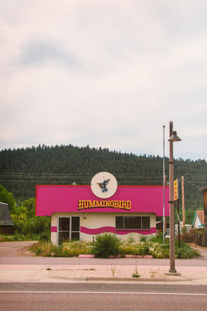 red and white concrete building near green trees under white sky during daytime