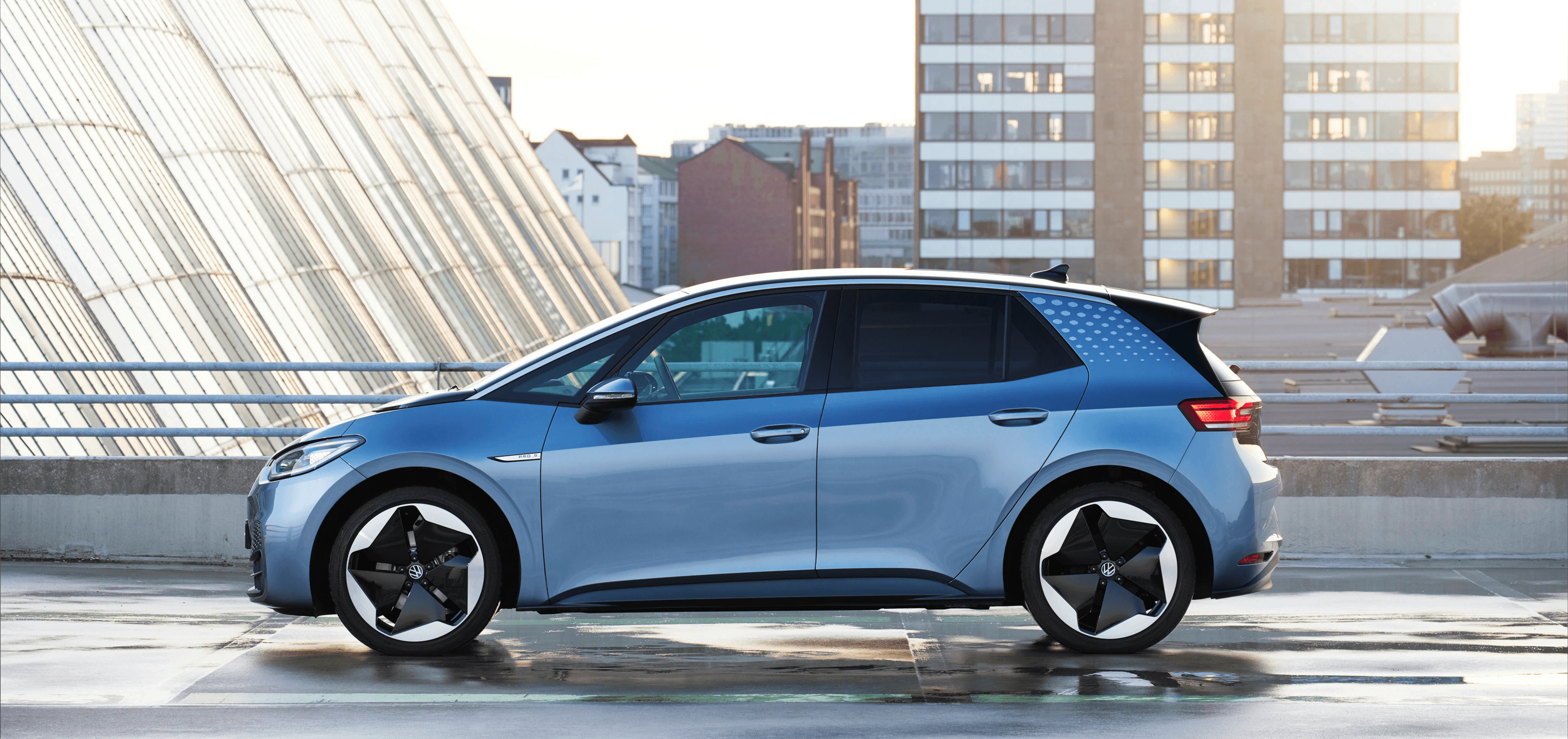 Volkswagen ID.3 bleue vue latérale dans un environnement urbain, compacte électrique au design épuré