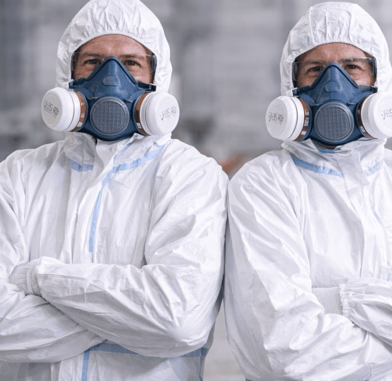 Stylish woman wearing an oversized cream quarter-zip sweatshirt and large sunglasses, looking to the side against a peach-colored wall.