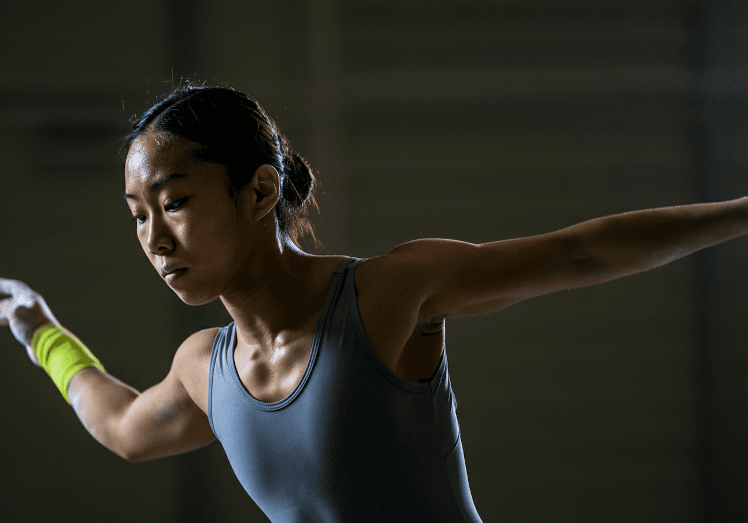 Focused female gymnast balancing with precision, demonstrating core control and body awareness—key elements in performance therapy and injury prevention.