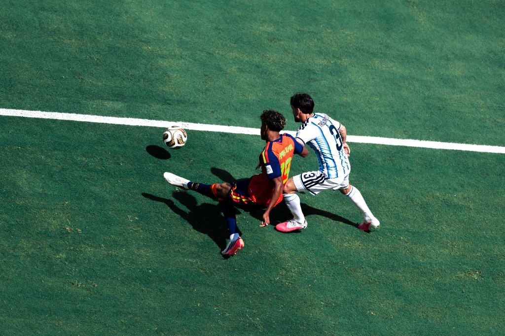 Spain's Lamine Yamal reaches for the ball under pressure from Argentina's Nicolas Tagliafico in the World Cup final