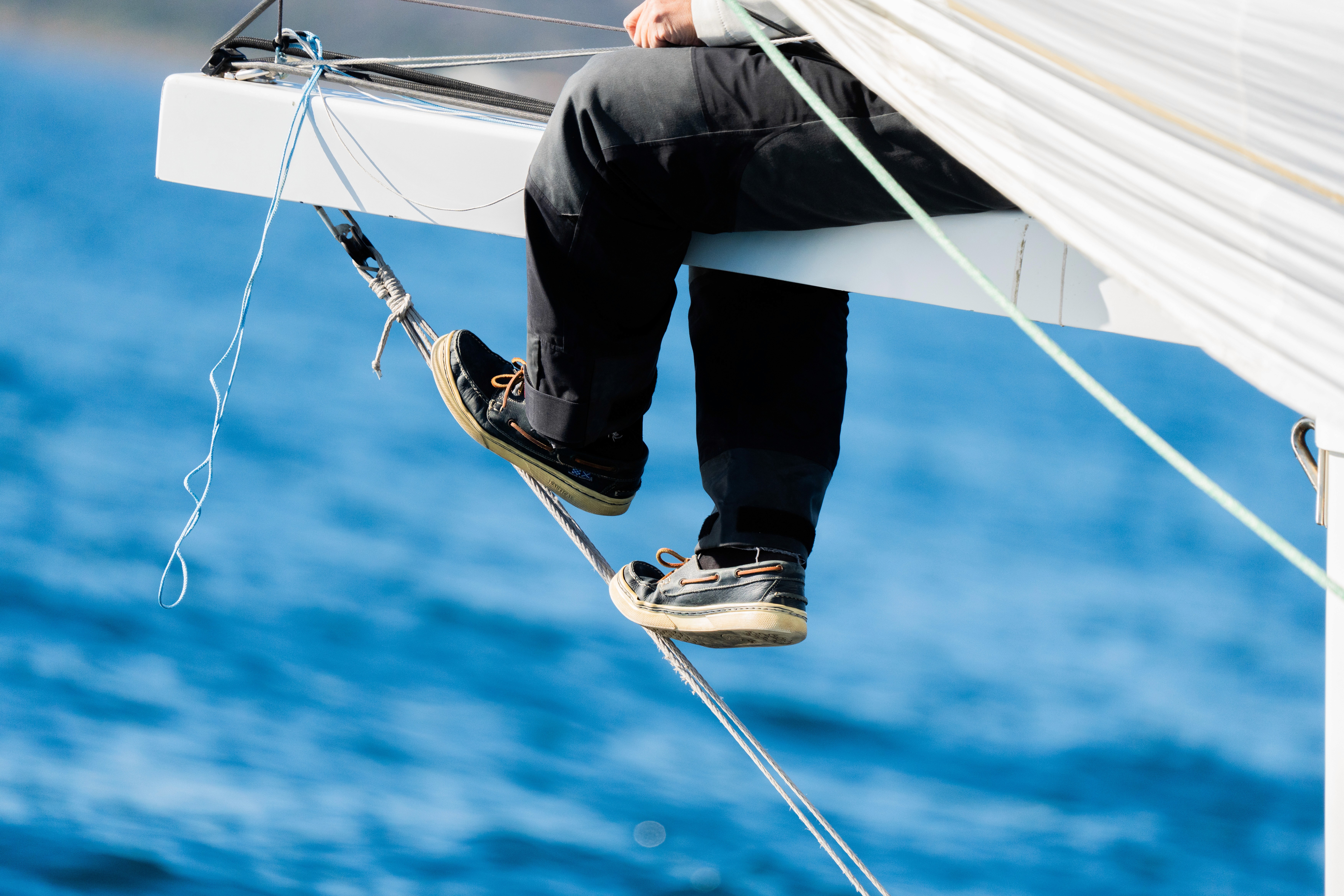 A man in a black jacket and hat stands confidently, showcasing a stylish and casual look.