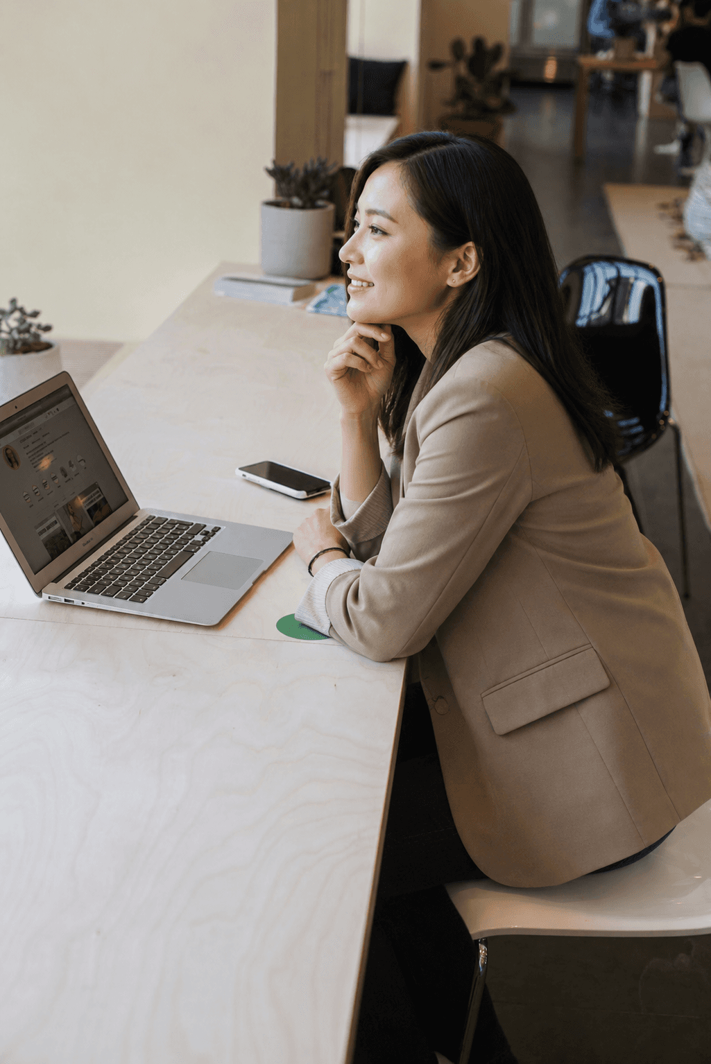 woman in brown coat using macbook air