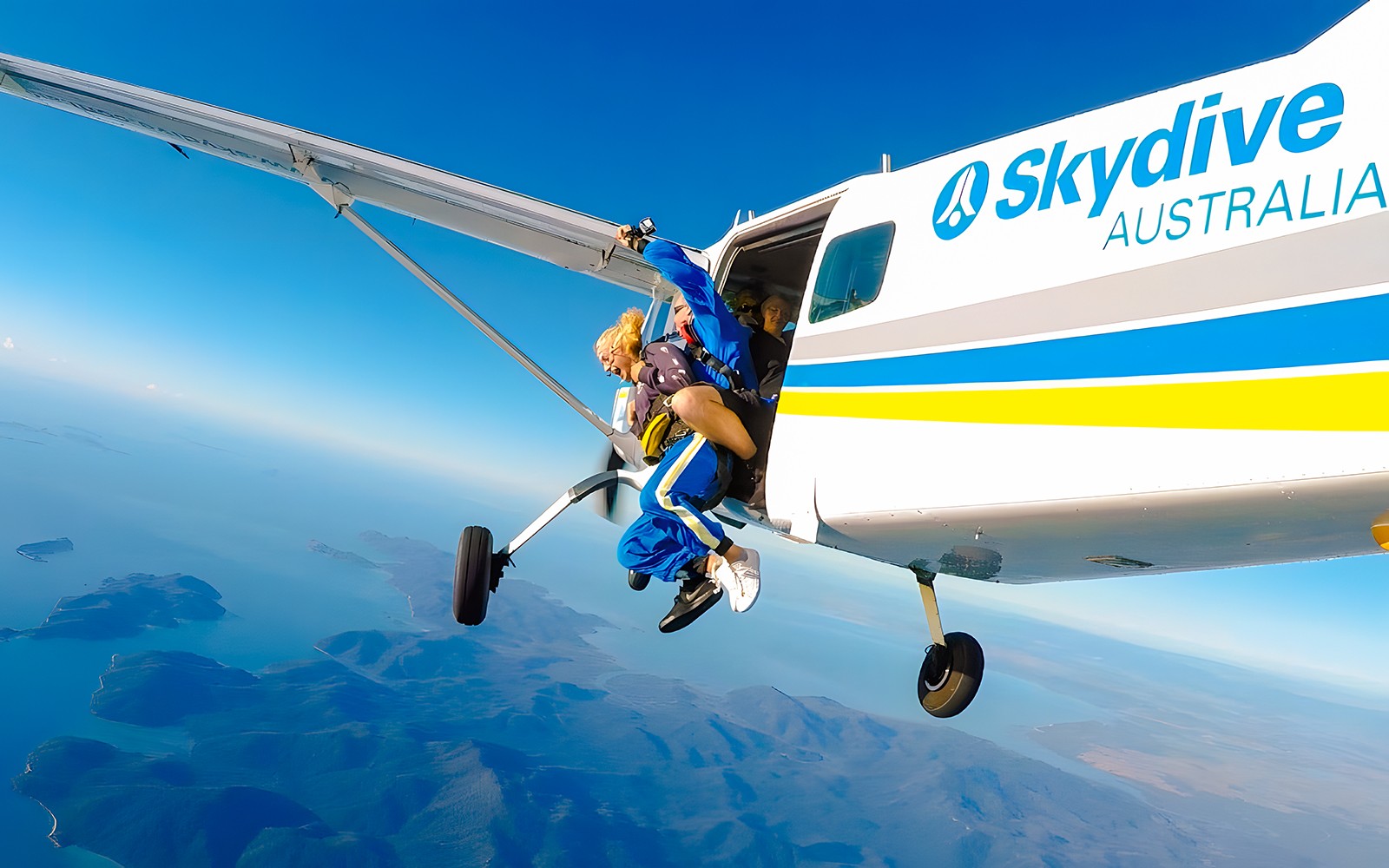 צניחה חופשית זוגית מעל חוף איירלי, המדריך והצנחן יוצאים מהמטוס.