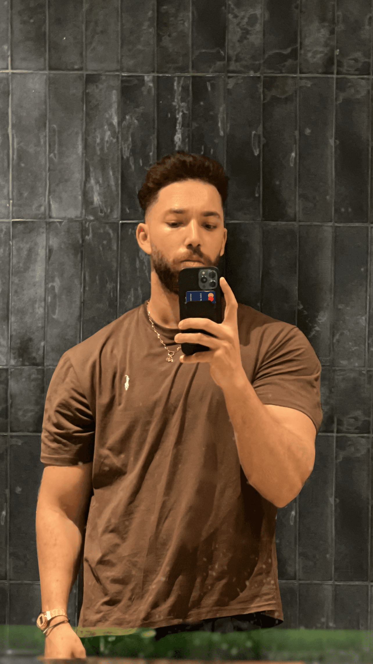 Close-up portrait of a freckled woman with soft pink hair and star earring, natural light, white tank top.