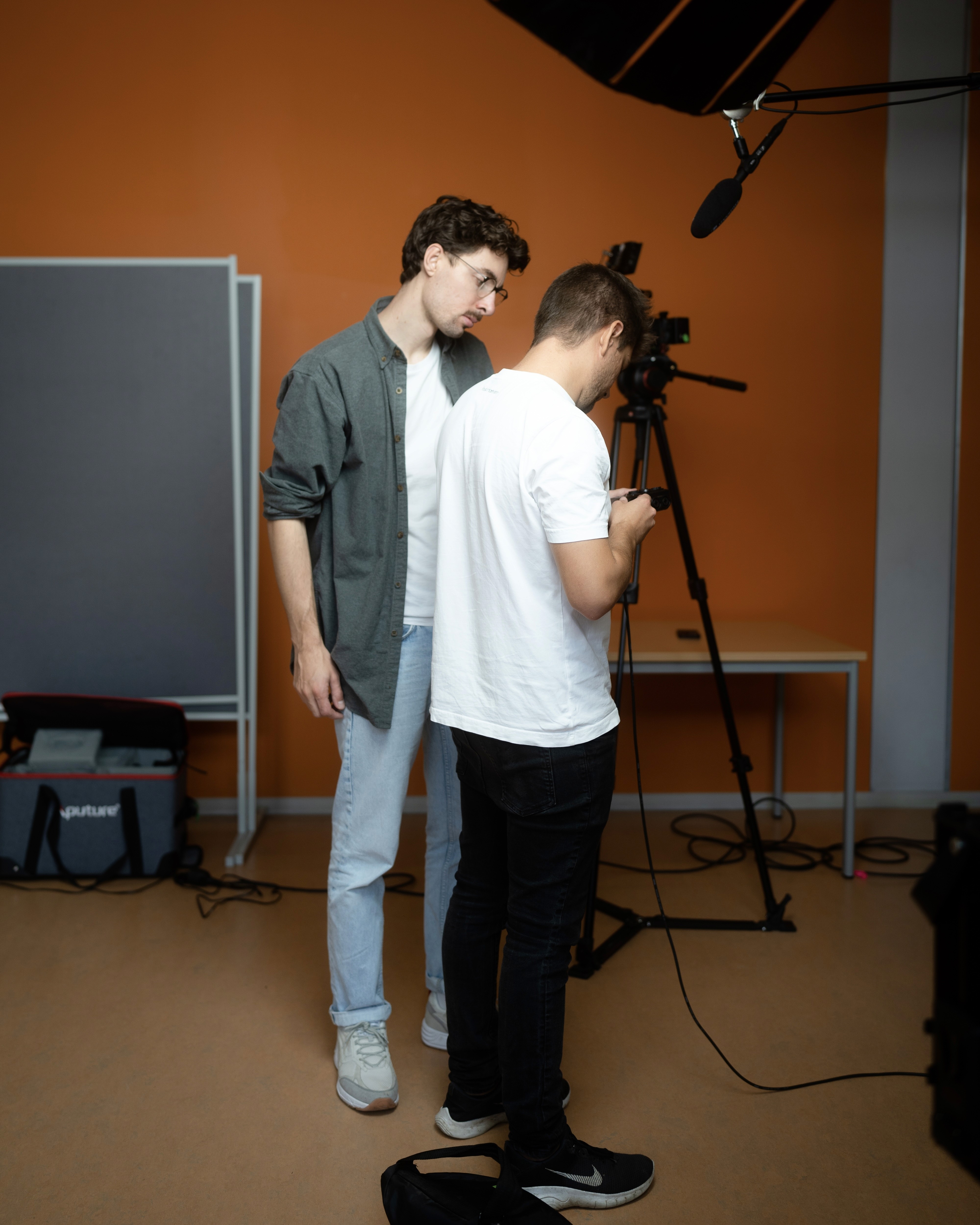 Green car under neon lights in a rainy city street