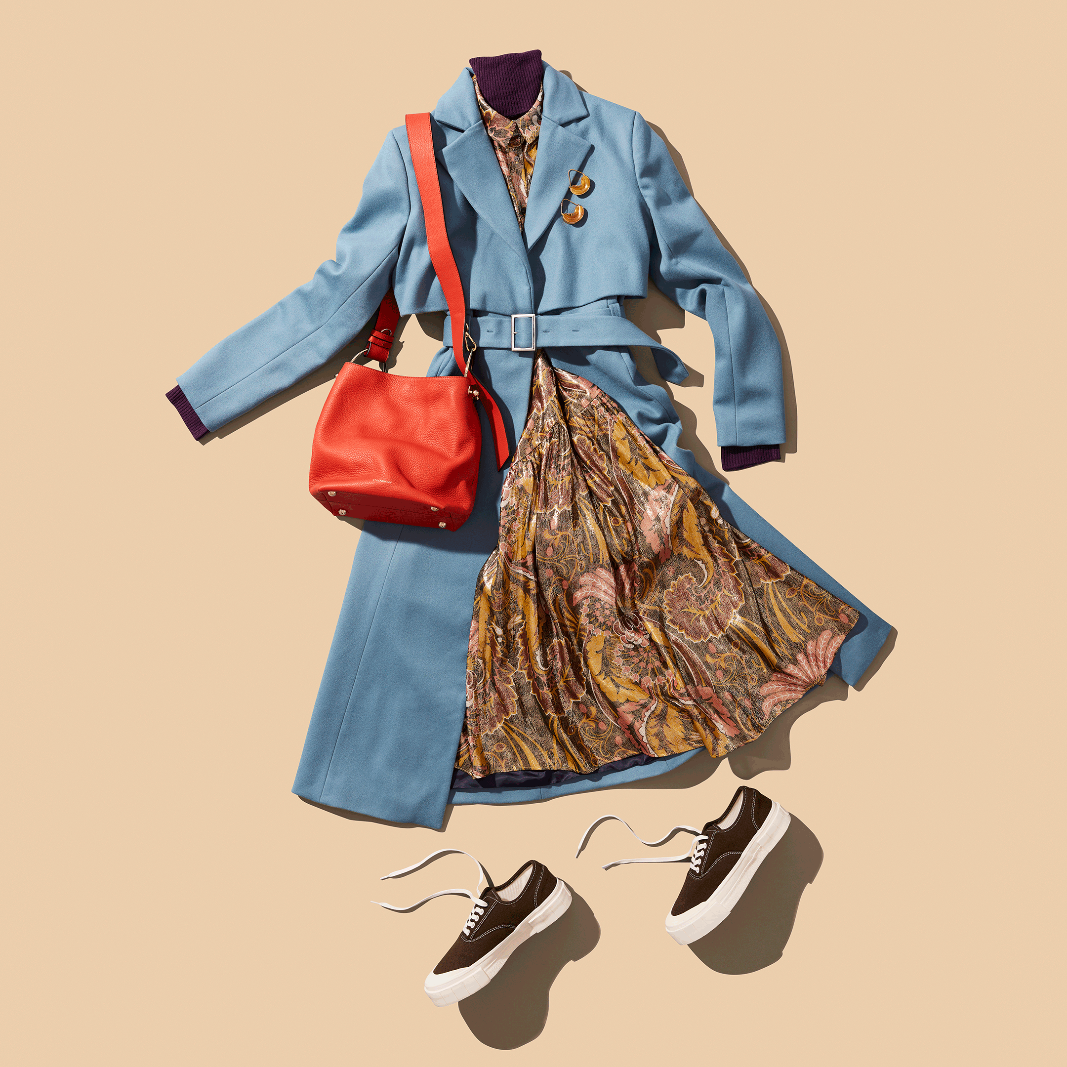Stylish fall outfit with blue coat, floral dress, red handbag, and sneakers on beige background.