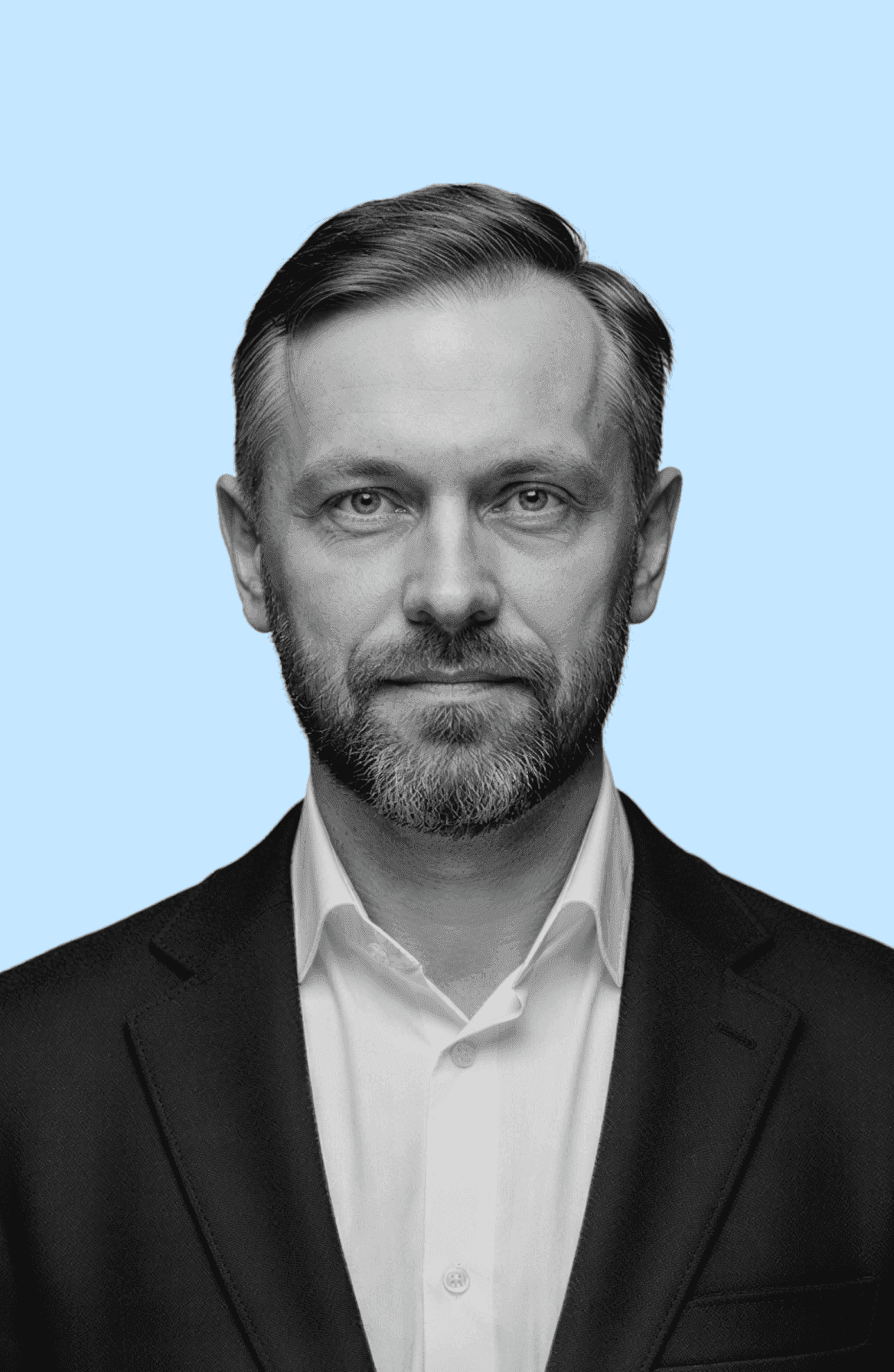 A black and white photo of a man wearing a suit, standing confidently with a serious expression.