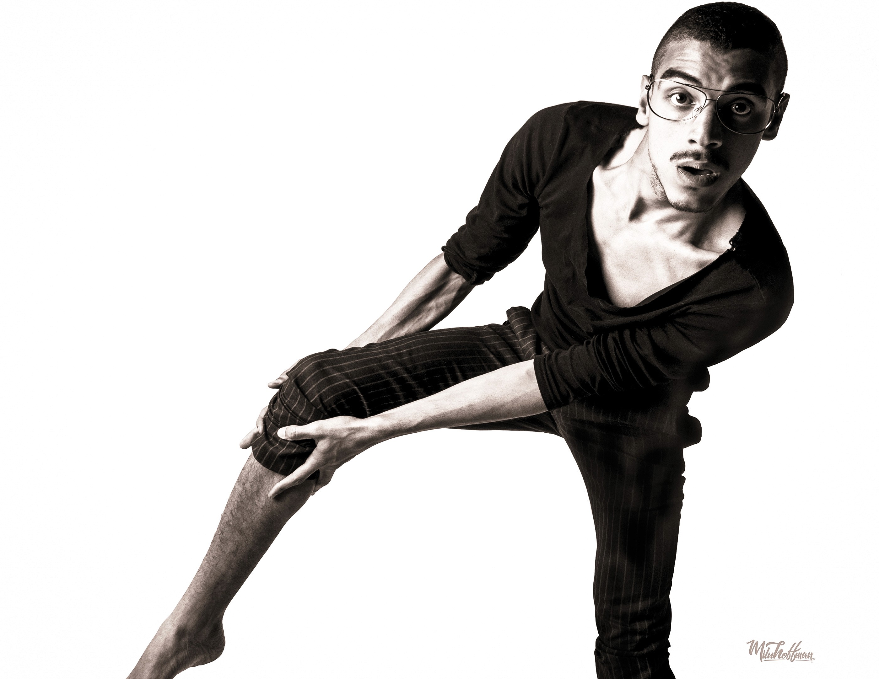 A high-key black and white studio shot capturing a moment of raw expression, showcasing the photographer’s ability to catch authentic movement and emotion in a controlled environment.