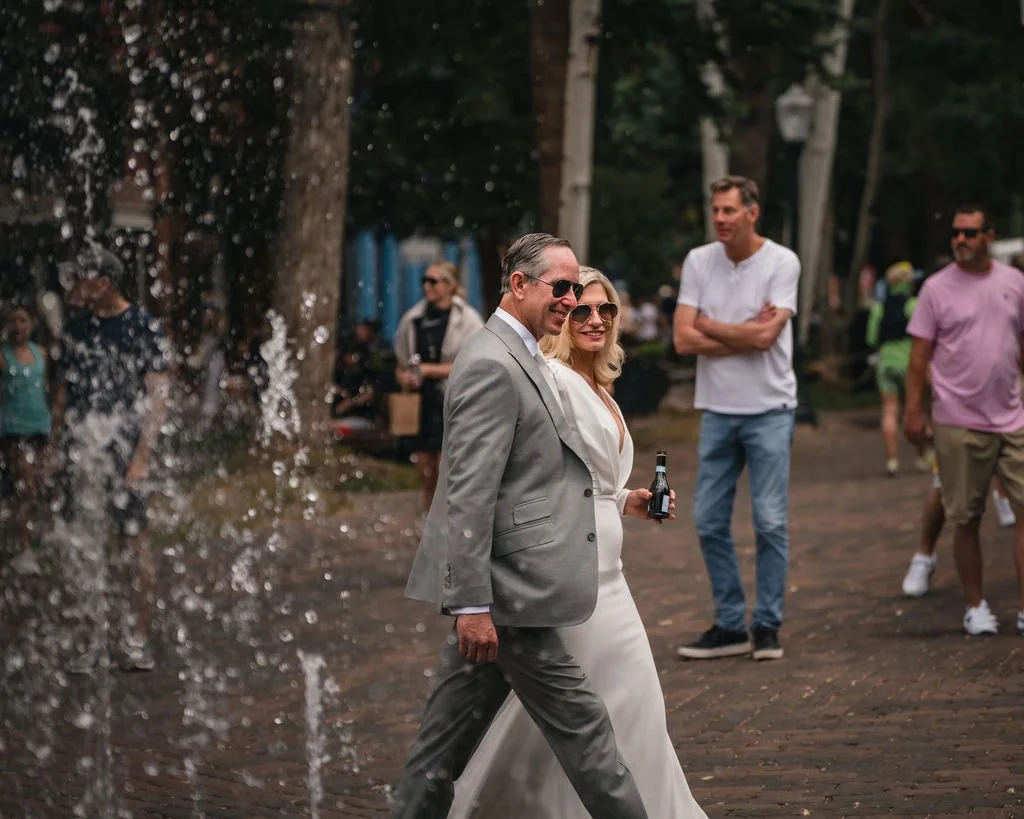 Groom walking past fountain jets outdoors