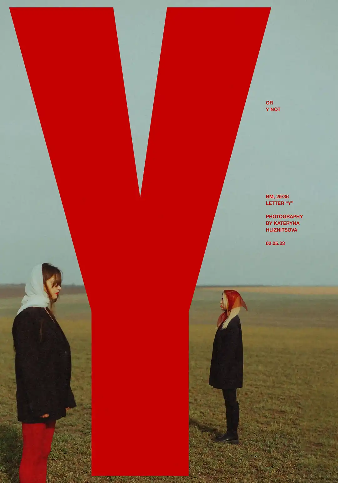 Two women in a field staring at a large letter 'Y'