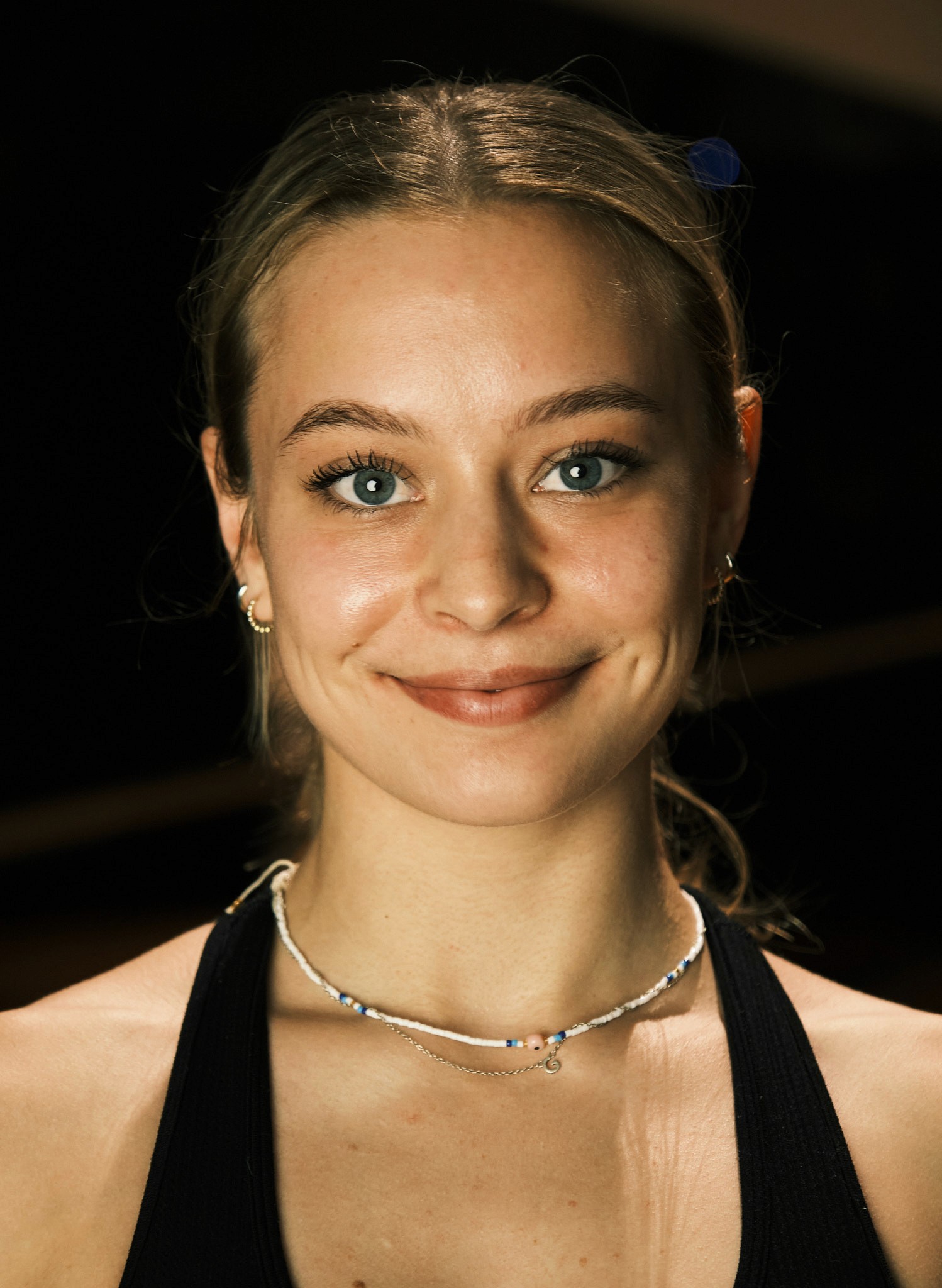 Black cosmetic product bottle against a dark background