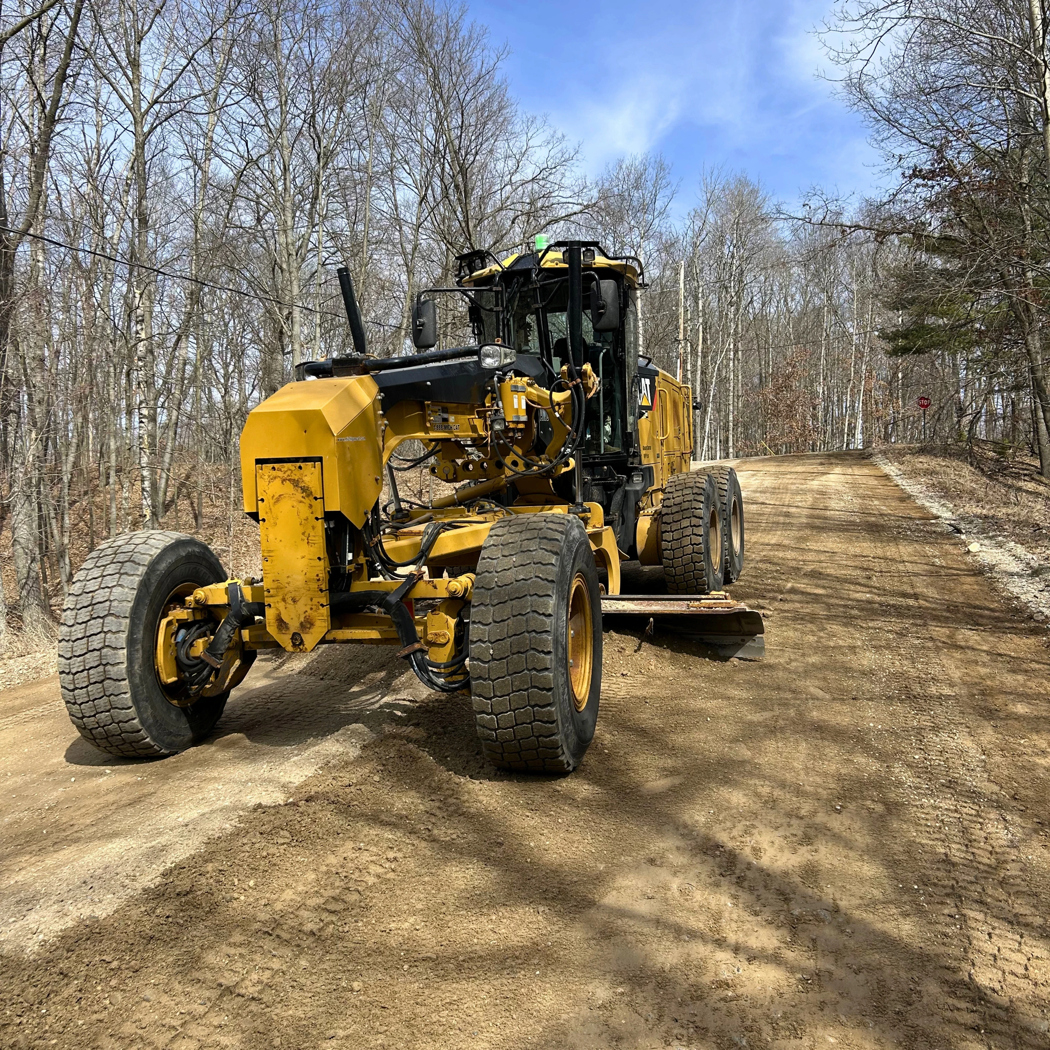 gray asphalt road between green grass field during daytime