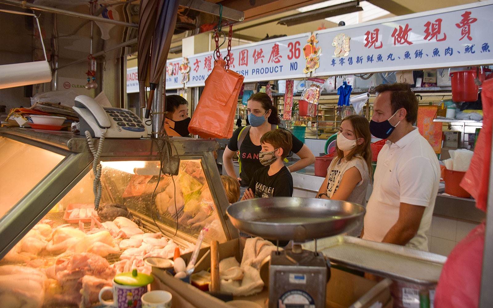 Singapore culinary tour with chef demonstrating cooking techniques at a local market.