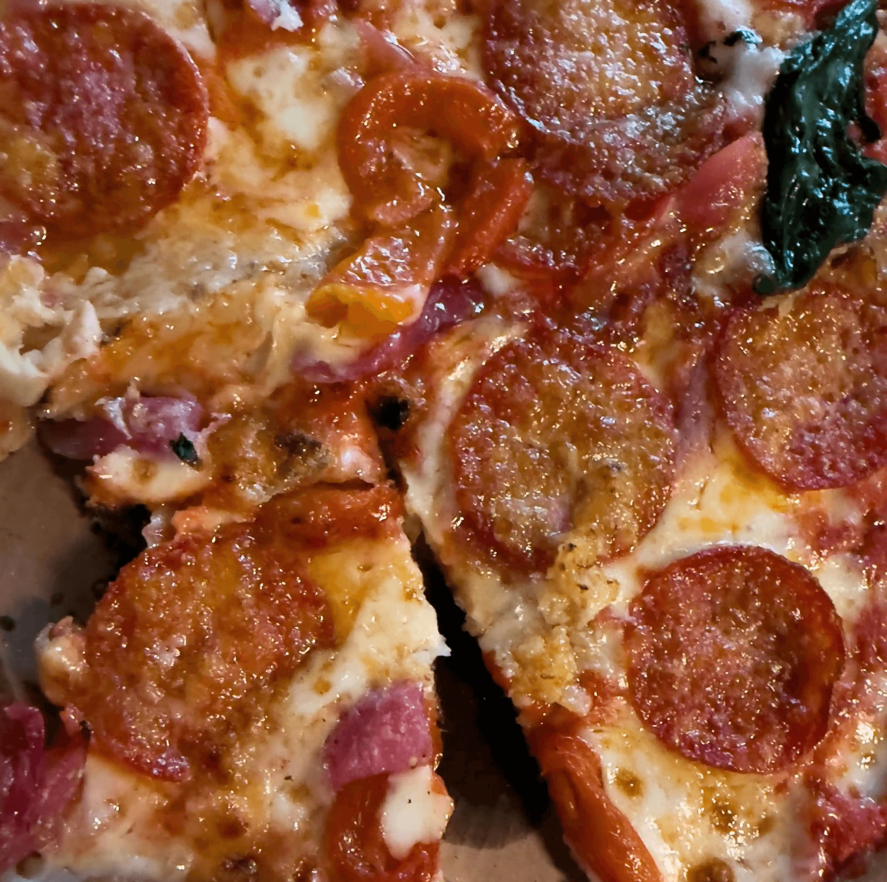 Freshly baked pizza topped with cheese, tomato, and fresh ingredients.