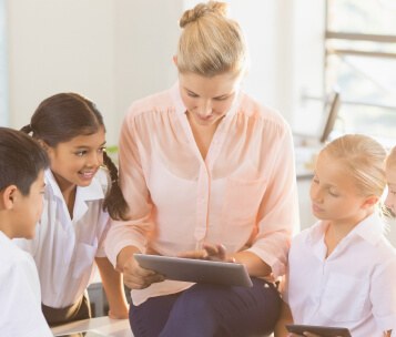 professora contando histórias para alunos com tablet