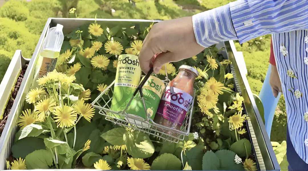 Hand holding Froosh juice in basket of flowers