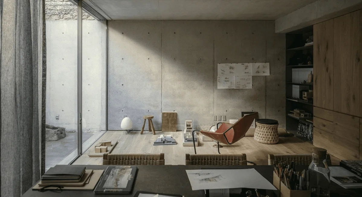 Un espacio de trabajo moderno con un escritorio con documentos y una gran ventana que proyecta sombras en las paredes.